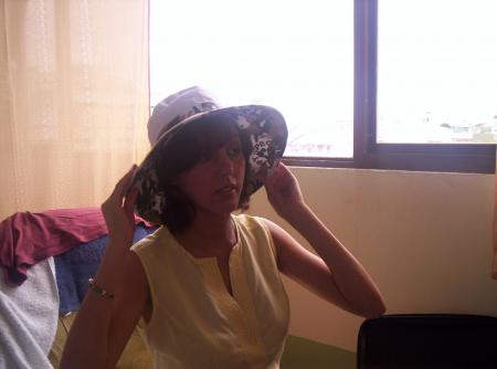 Maman essaie un chapeau avant de sortir.