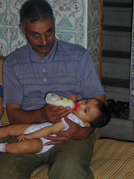 Grand père Ali me donne le biberon.